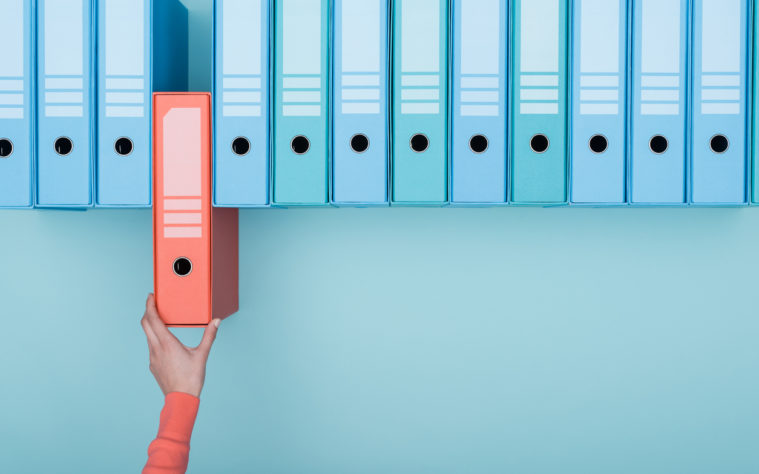 Office worker taking a folder in the archive